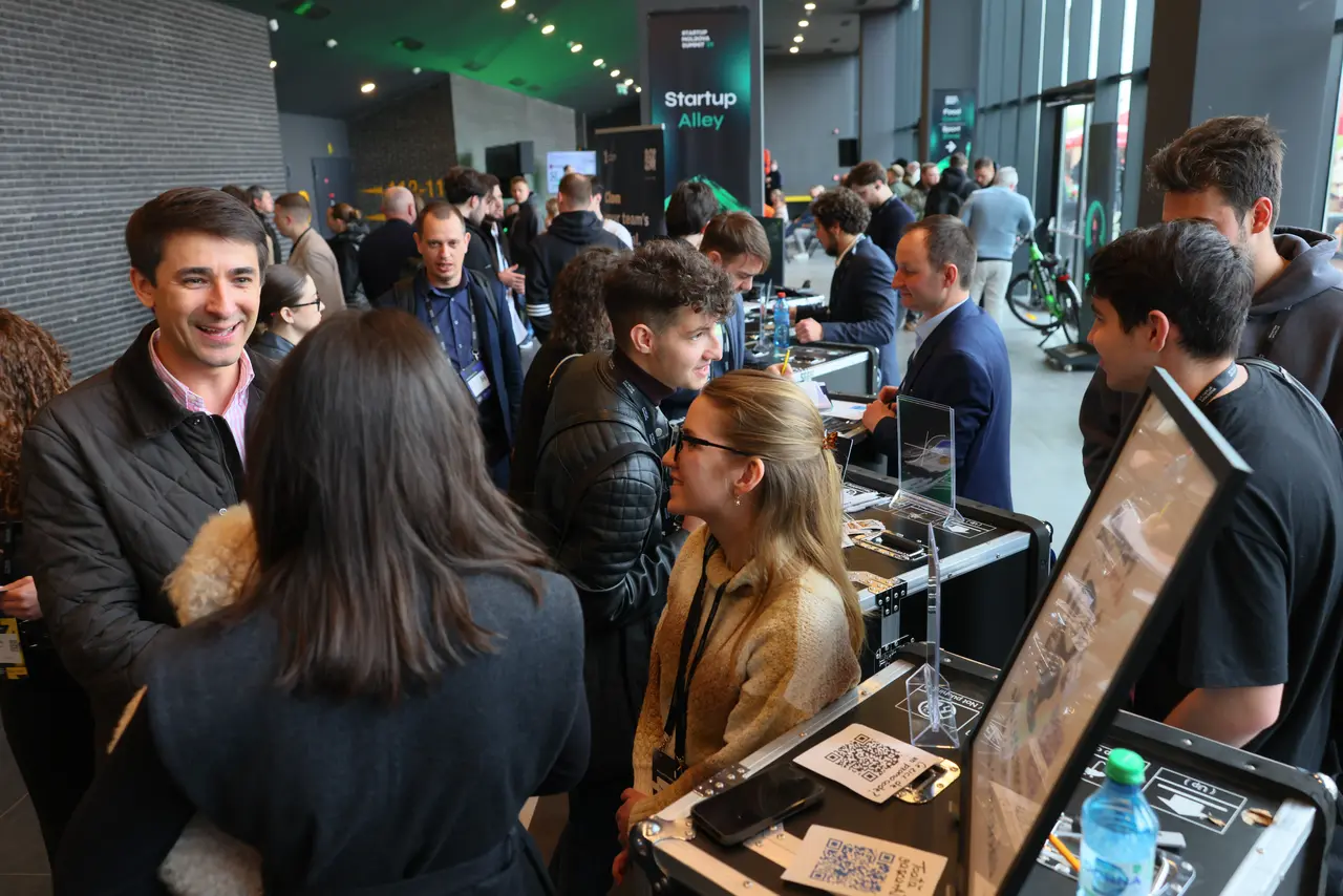 Attendees networking around startup booths